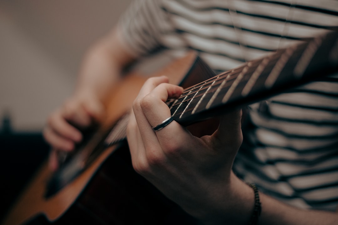a person holding a guitar and playing the guitar