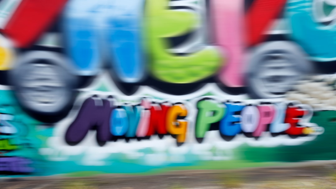 a man riding a skateboard past a graffiti covered wall