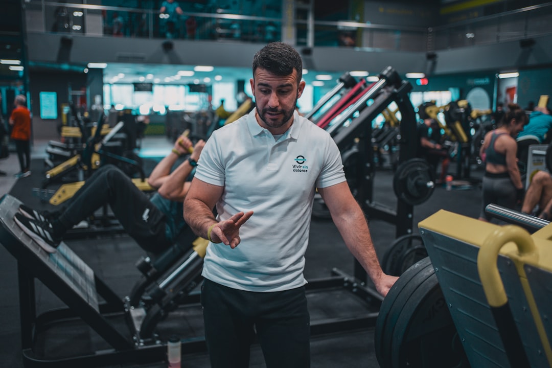 A man standing in a gym holding a cell phone